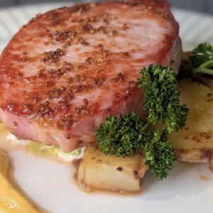Côtelette de bacon glacée rôtie de Trisha avec chou de Savoie braisé, sauce à la crème moutarde et pommes de terre grelots au beurre