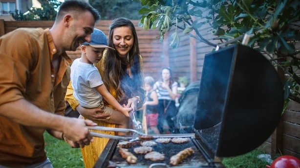 Jeune famille heureuse ayant une fête barbecue dans la cour