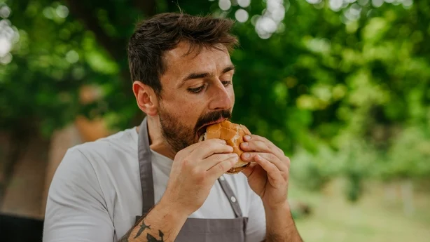 Homme savourant la saveur d'un hamburger barbecue fait maison